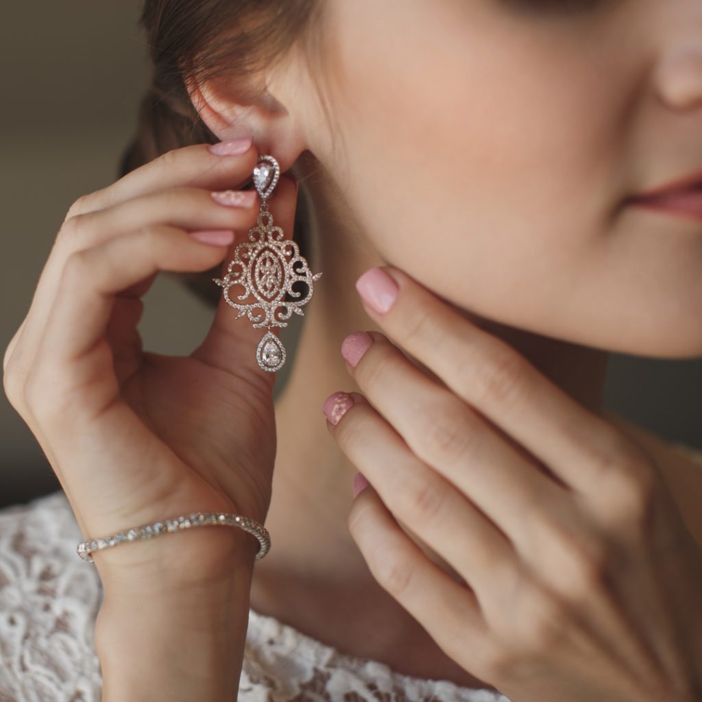 A woman adjusts her beautiful new earrings before heading out.