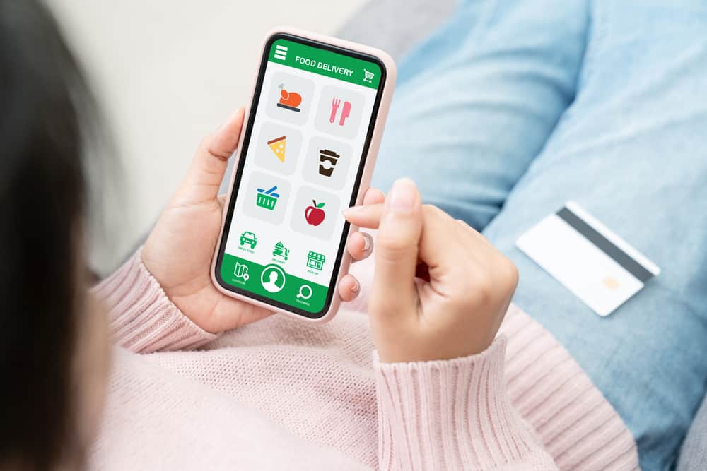 A woman looks at her phone while shopping online.