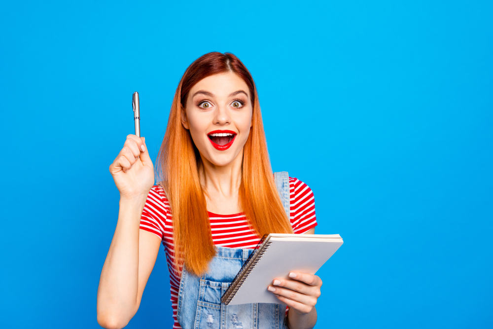 A woman holding a notepad and a pen has a great idea!