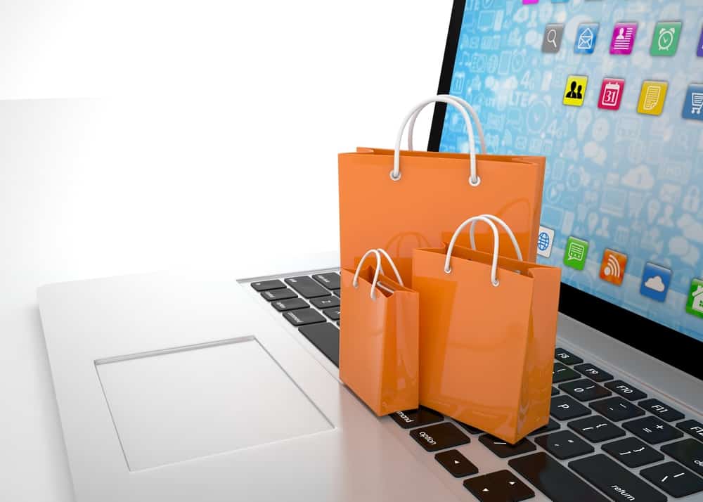 Miniature shopping bags sit on a laptop keyboard representing a great online shopping experience.
