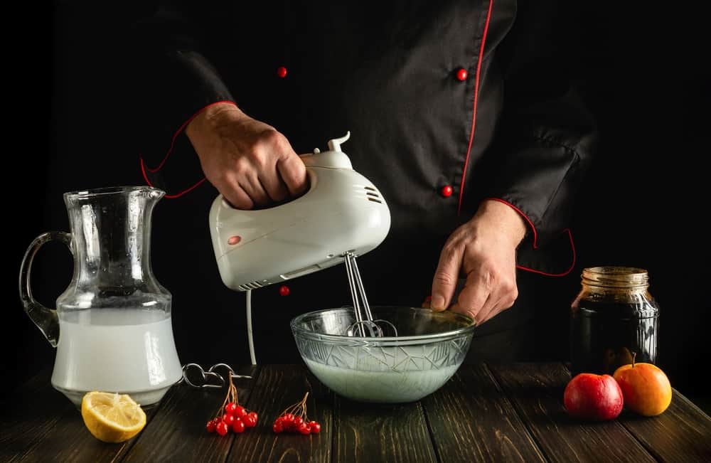A chef uses a hand mixer to create something delicious!